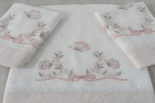 Delicate embroidery design featuring butterflies, flowers, and bows on white fabric.